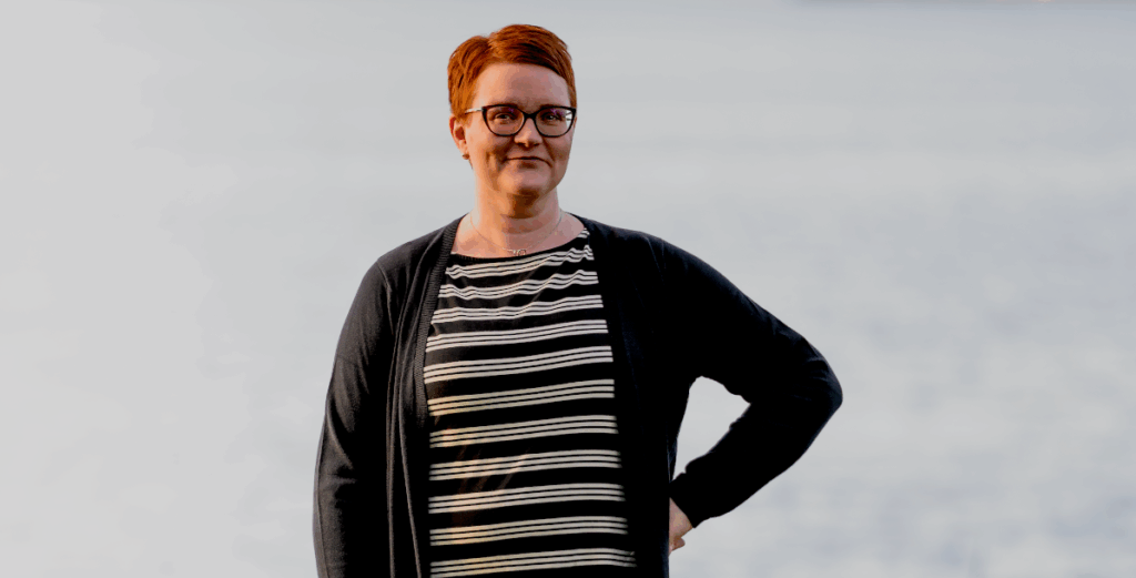 Tiina julin hymyilee ja katsoo kameraan.